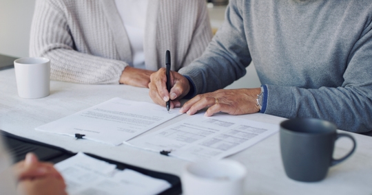 couple signing documents at an office